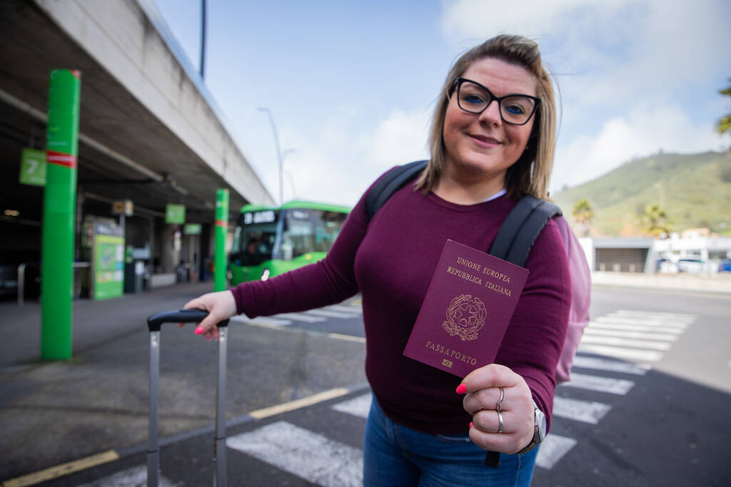 Uma turista italiana segura seu passaporte na mão enquanto está na rodoviária